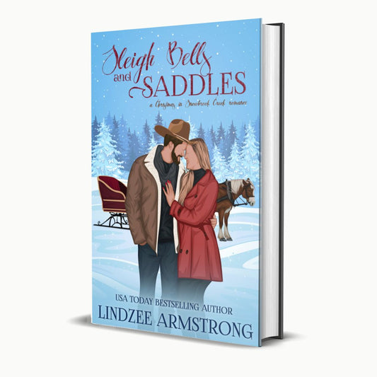 Sleigh Bells and Saddles by Lindzee Armstrong hardback, clean Christmas romantic comedy in the Christmas in Snowbrook Creek series